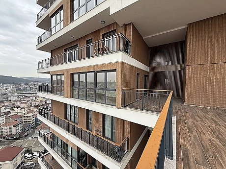 Şehir ve orman manzarasına hakim, modern mimariye sahip geniş bir daire terası.