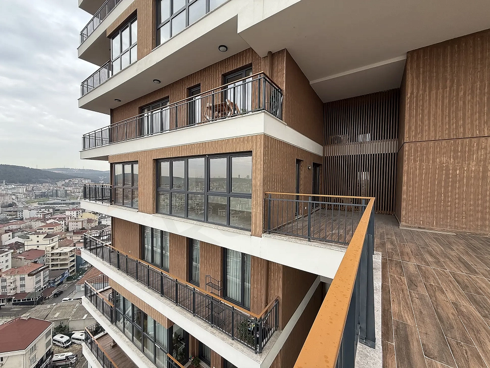 Şehir ve orman manzarasına hakim, modern mimariye sahip geniş bir daire terası.