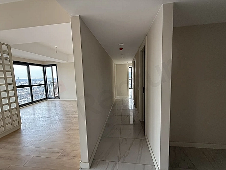 Modern bir binada yer alan, geniş ve aydınlık bir daire koridoru.