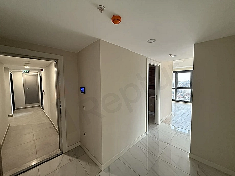 Modern bir dairenin giriş kapısı ve antre alanı görünümü.