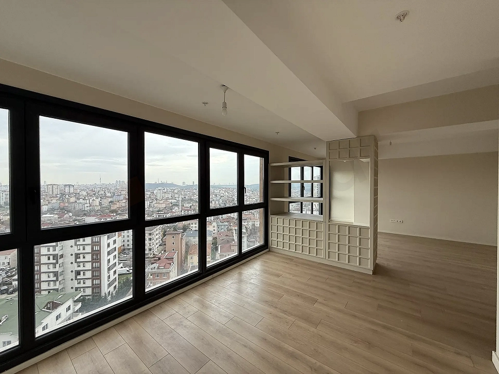 Geniş pencereli, gün ışığı alan modern ve ferah bir oturma odası görünümü.