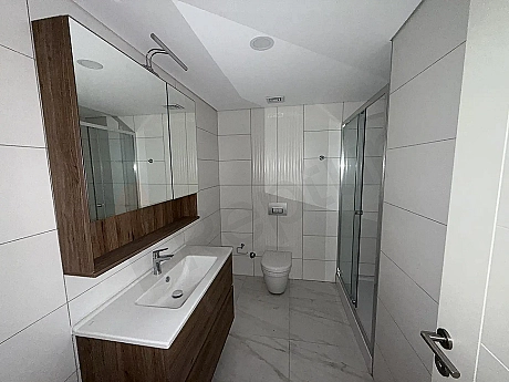 Modern tasarımlı, şık seramik döşemeli ve geniş bir banyo alanı.