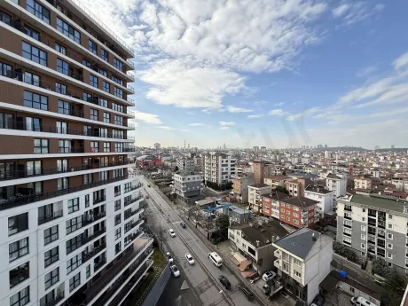 Şehir silüeti ve geniş yeşil orman alanını bir arada sunan panoramik manzara görüntüsü.