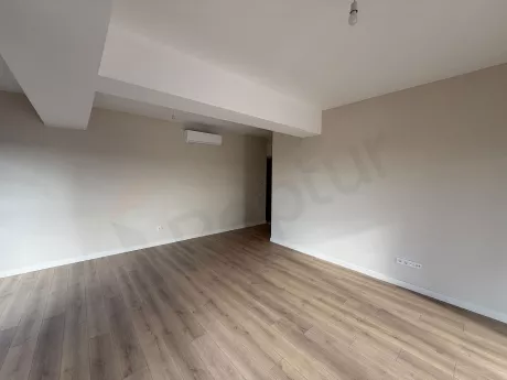 Modern mimariye sahip, geniş pencereli ve ferah bir oturma odası alanı.
