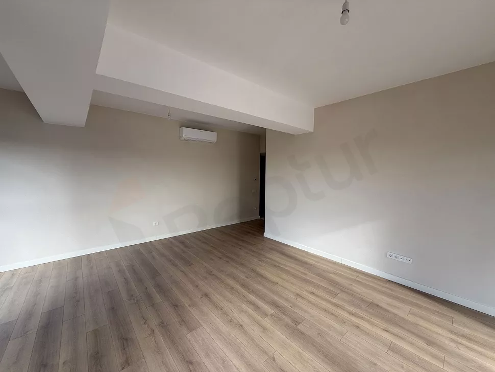 Modern mimariye sahip, geniş pencereli ve ferah bir oturma odası alanı.
