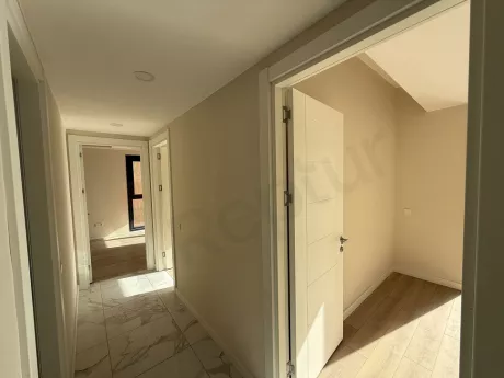 Yeni inşa edilmiş modern bir dairenin geniş ve aydınlık koridor görünümü.