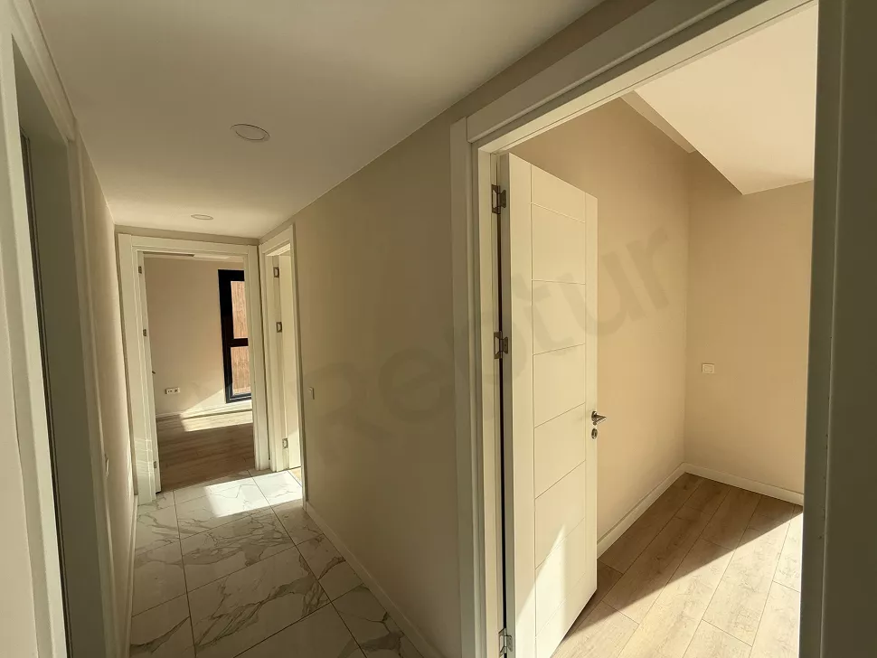 Yeni inşa edilmiş modern bir dairenin geniş ve aydınlık koridor görünümü.