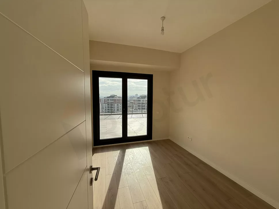 Modern mimariye sahip, geniş pencereli, ferah ve aydınlık boş yatak odası iç mekanı.