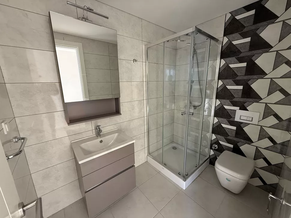 Modern tasarımlı, kaliteli seramik kaplamalı ve şık armatürlerin bulunduğu geniş banyo.