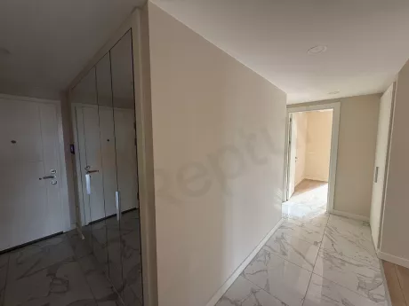 Modern bir binada yer alan dairenin giriş kapısı ve antre bölümü.