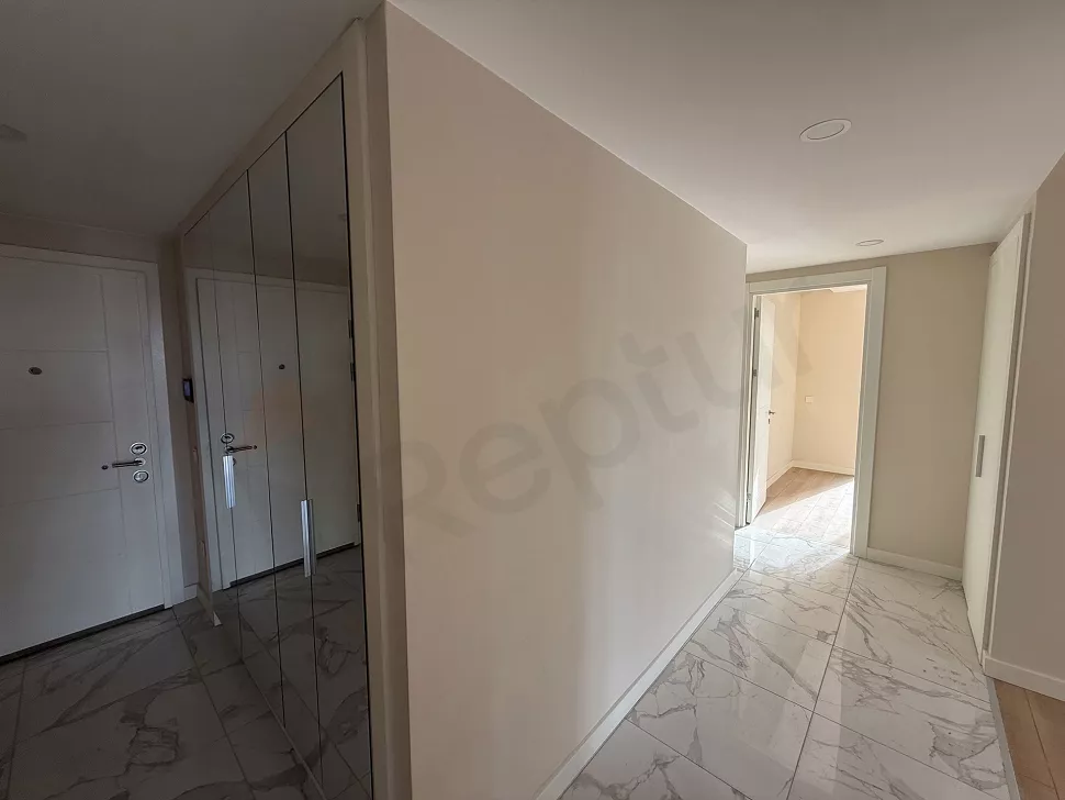 Modern bir binada yer alan dairenin giriş kapısı ve antre bölümü.