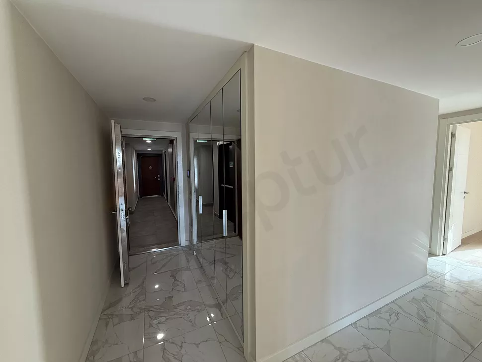 Modern bir apartman dairesinin giriş kapısı ve antre bölümünün iç mekandan görünümü.