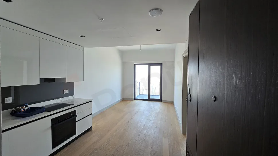 Modern ve geniş pencereli aydınlık bir oturma odası alanı.