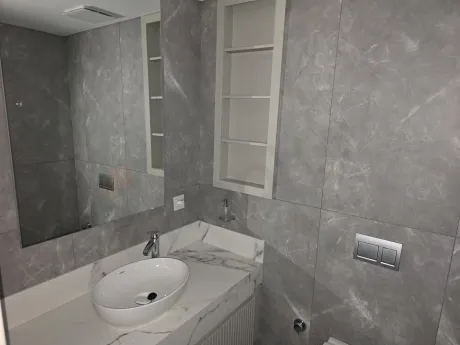 Modern tasarımlı, şık seramik kaplamalı ve kaliteli vitrifiye ürünlerine sahip lüks banyo görünümü.