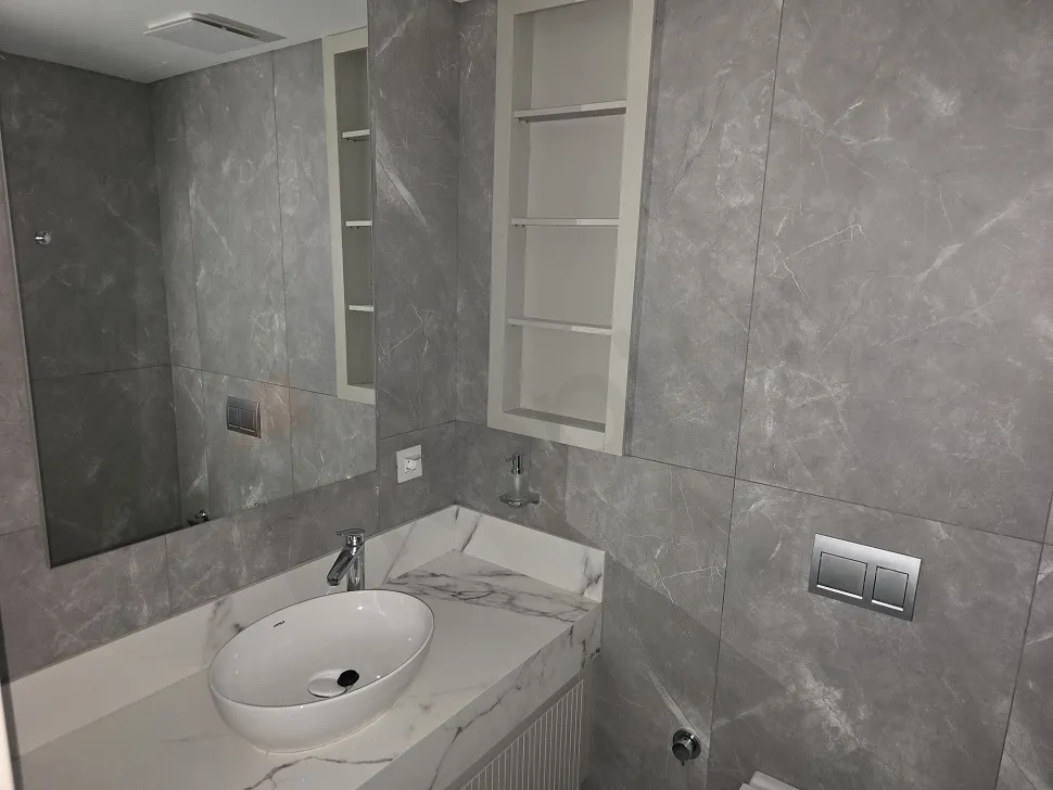 Modern tasarımlı, şık seramik kaplamalı ve kaliteli vitrifiye ürünlerine sahip lüks banyo görünümü.