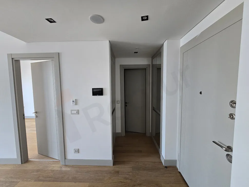Modern bir rezidans binasında yer alan şık ve aydınlık daire girişi alanı.
