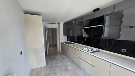 Modern tasarımlı, geniş dolaplı ve tezgahlı aydınlık mutfak alanı.