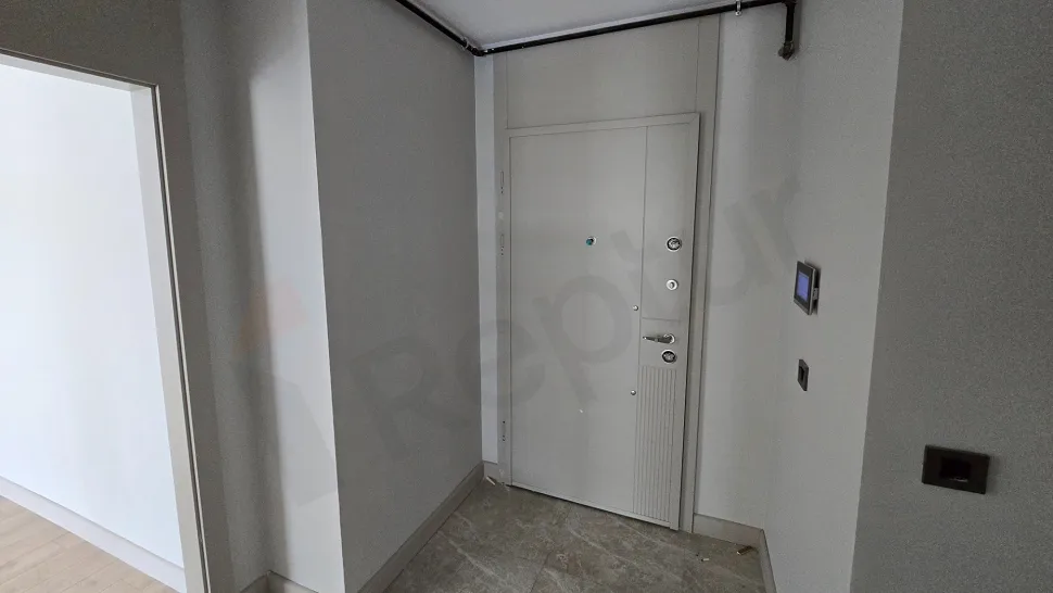 Modern bir apartman dairesinin giriş kapısı ve antre bölümünün görünümü.