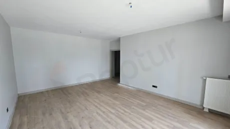 Geniş pencereli, şehir manzaralı, aydınlık ve modern mimariye sahip boş bir oturma odası.