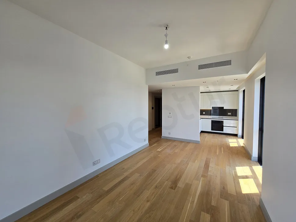 Şişli'de modern mimariye ve geniş pencerelere sahip, şehir manzaralı aydınlık boş oturma odası.
