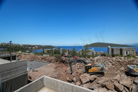Lüks villanın terasından çekilmiş, masmavi deniz ve sahil şeridini gören panoramik manzara.