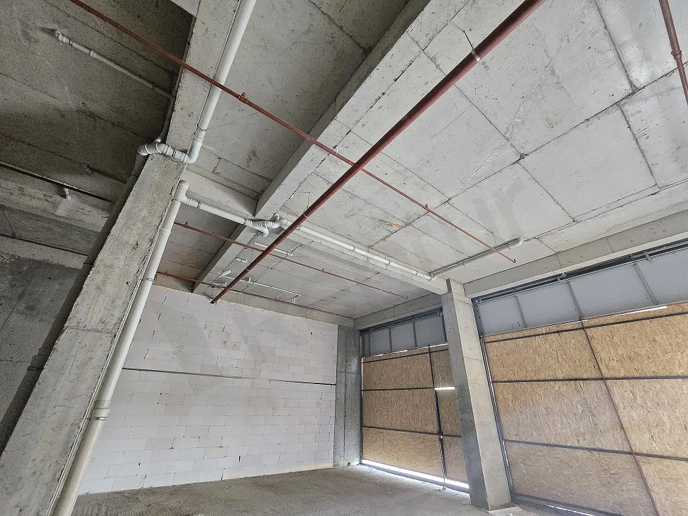 Pendik'te satılık 306 m2 geniş, natamam dükkanın beton zeminli ve kolonlu iç mekan görünümü.