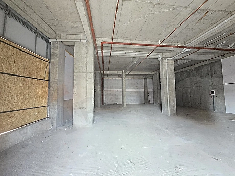 Beton kolonların ve geniş alanın görüldüğü natamam dükkan iç mekan görünümü