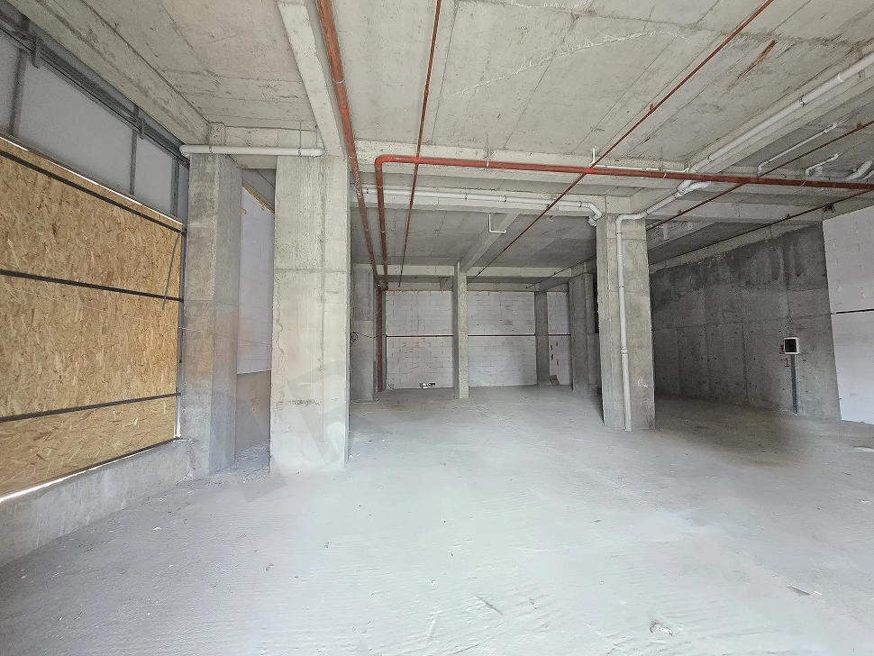 Beton kolonların ve geniş alanın görüldüğü natamam dükkan iç mekan görünümü