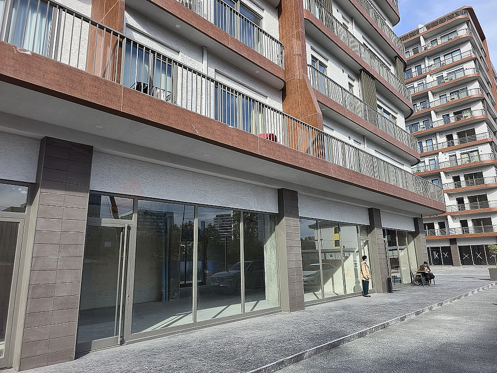 Modern mimariye sahip, güneş panelleriyle donatılmış, yeni yapılmış bir binanın dış cephesi.