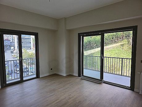 Modern tasarımlı, eşyasız, aydınlık oturma odası görseli.