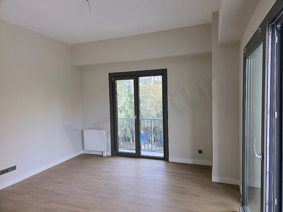 Modern oturma odası iç mekanı: Gri köşe koltuk, ahşap sehpa, beyaz duvarlar ve doğal ışık.