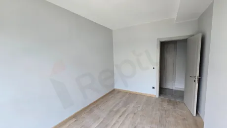 Yeni bir dairenin modern ve geniş pencereli aydınlık yatak odası görseli.