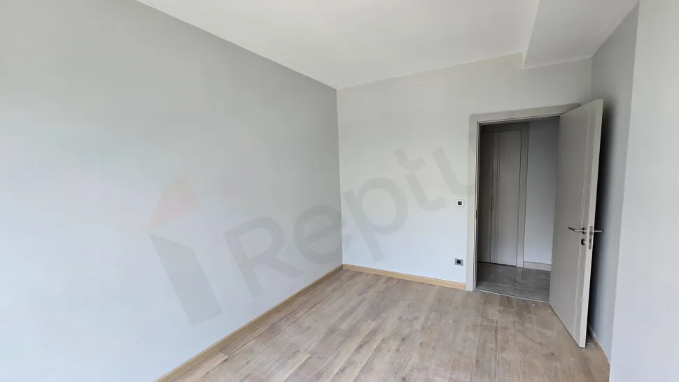 Yeni bir dairenin modern ve geniş pencereli aydınlık yatak odası görseli.