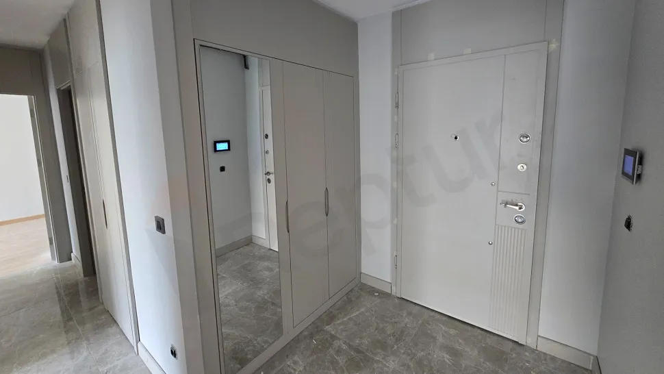 Modern bir dairenin giriş kapısı ve antre bölümü.