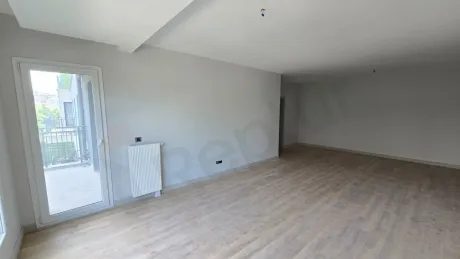 Modern bir yapıda yer alan, geniş pencereli ve ferah atmosferli gün ışığı alan oturma odası alanı.