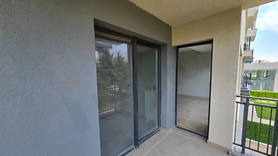Modern bir binada yer alan geniş ve ferah bir balkon görüntüsü.