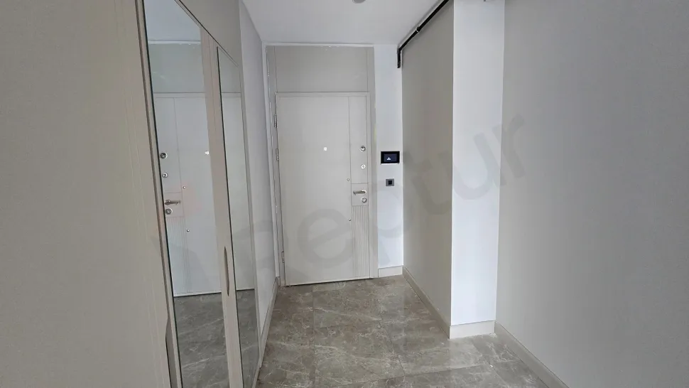 Modern tasarımlı bir dairenin giriş kapısı ve antre bölümü.