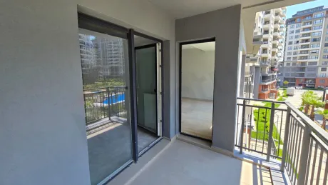 Yeni inşa edilmiş lüks bir binada yer alan geniş ve modern balkon görüntüsü.