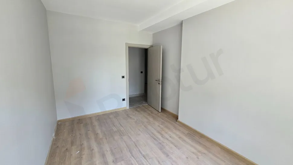 Modern ve aydınlık tasarıma sahip geniş bir yatak odası görünümü.