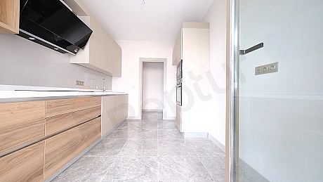 Modern tasarımlı, eşyasız bir mutfak.