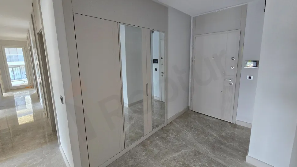 Modern ve geniş bir dairenin giriş alanı ve antre bölümü.