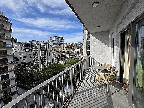 Eşyalı teras görseli. Teras oturma alanı, bitkiler ve şehir manzarası.