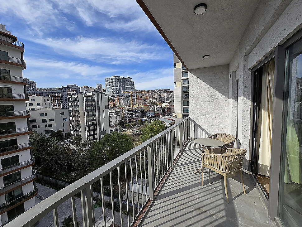 Eşyalı teras görseli. Teras oturma alanı, bitkiler ve şehir manzarası.