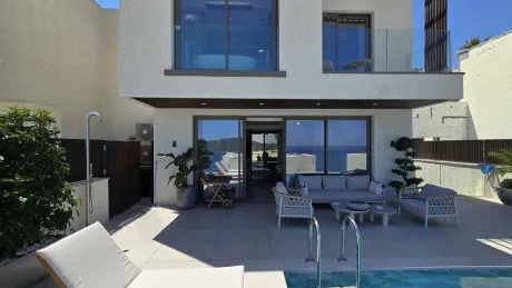 Deniz manzarasına bakan modern ve geniş bir villa terası.