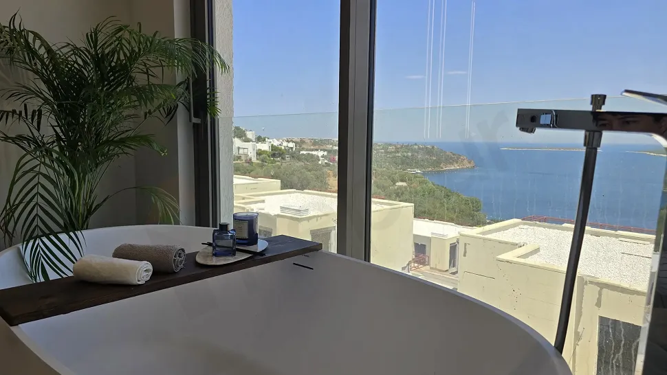 Deniz manzaralı, geniş pencereli ve modern tasarımlı banyo iç mekanı.