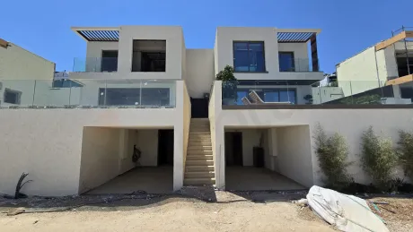 Doğal taş kaplamalı iki modern villanın dış cephe mimari görünümü.
