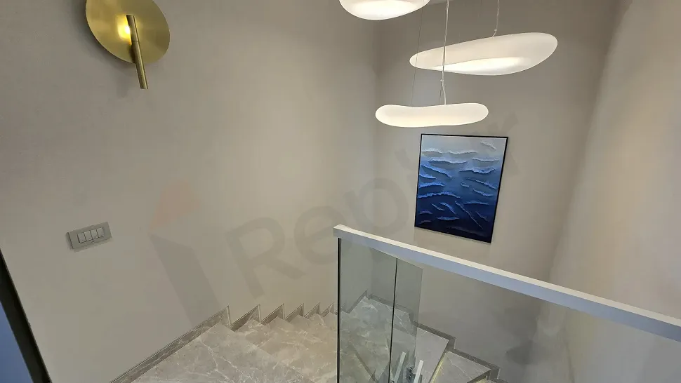Modern mimari tasarıma sahip villa içi şık merdiven görüntüsü.