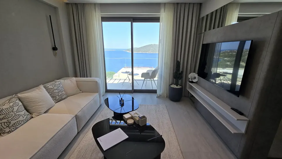 Modern tasarımlı, geniş pencereli ve ferah lüks villa oturma odası alanı.