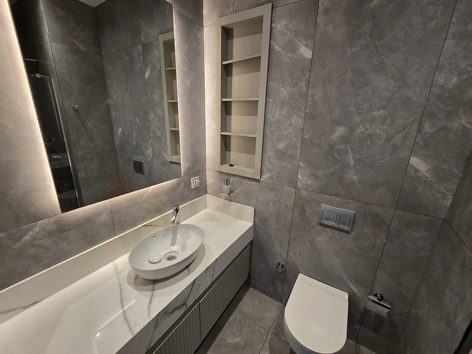 Modern ve şık bir banyo tasarımı, kaliteli seramik kaplamalar ve banyo aksesuarları.