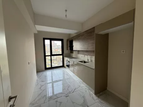 Modern tasarımlı, geniş dolaplı ve tezgah alanına sahip aydınlık mutfak.